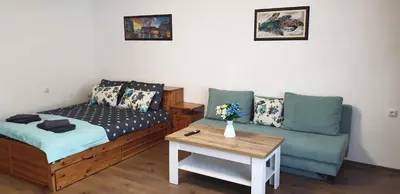 a room with a bed and a couch and a table at Къща за гости Кралимаркови Guest house Kralimarkovi in Devin
