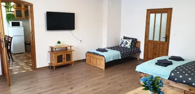 a room with a bed and a chair and a television at Къща за гости Кралимаркови Guest house Kralimarkovi in Devin