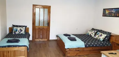 a bedroom with two beds and a table and a door at Къща за гости Кралимаркови Guest house Kralimarkovi in Devin
