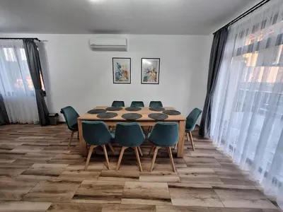 a dining room with a table and blue chairs at Къщи за гости 