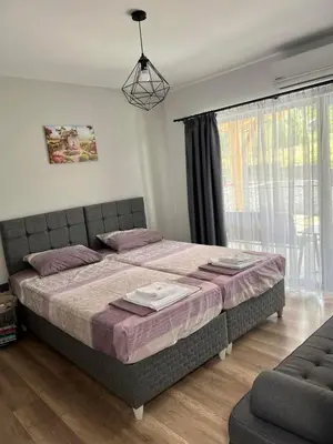 a bedroom with a large bed and a window at Къщи за гости 