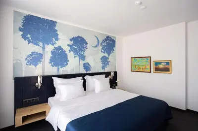a bedroom with a large bed with a blue and white wall at Blue Star Luxury Hotel in Sofia