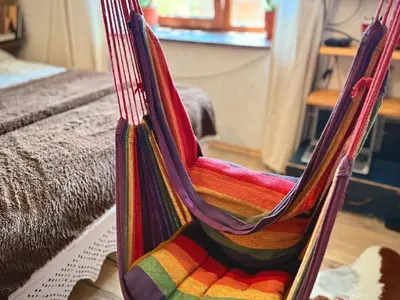 a colorful hammock in a room with a bed at Books Houses in Beden