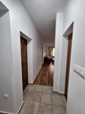 a hallway with white walls and a wooden door at Apartment Pirin in Bansko