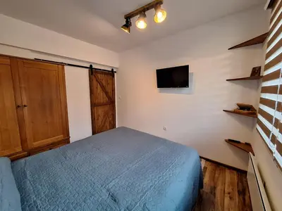 a bedroom with a bed and a tv on the wall at Apartment Pirin in Bansko
