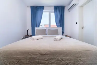 a bedroom with a large bed with blue curtains at Serene Luxe Oasis Retreat on the Outskirts by Flat Mаnager in Plovdiv