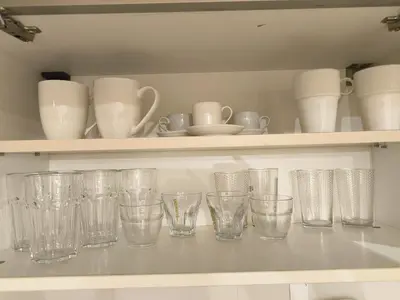 a row of empty glasses on a shelf at Cozy 1 bdrm, top center, Solunska near Vitoshka street in Sofia