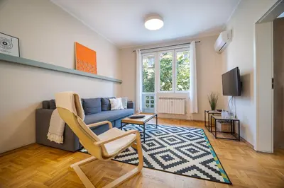 a living room with a blue couch and a tv at Cozy 1 bdrm, top center, Solunska near Vitoshka street in Sofia