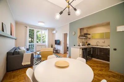 a living room with a white table and a kitchen at Cozy 1 bdrm, top center, Solunska near Vitoshka street in Sofia