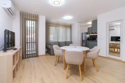 a living room with a table and chairs and a kitchen at Modern 1-Bedroom Apartment with Free Parking in Plovdiv
