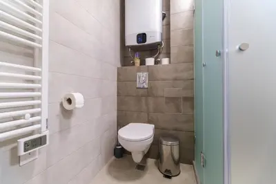 a small bathroom with a toilet and a shower at Modern 1-Bedroom Apartment with Free Parking in Plovdiv