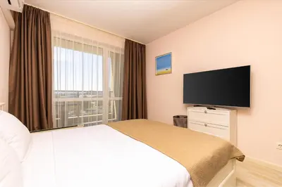 a hotel room with a bed and a flat screen tv at Bright and Cozy 1BD Flat in Plovdiv with Parking by Flat Mаnager in Plovdiv
