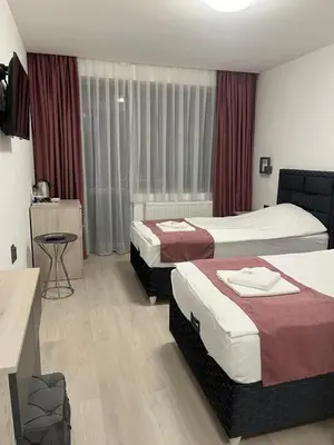 a hotel room with two beds and a table at Хотел Лилия in Rudozem