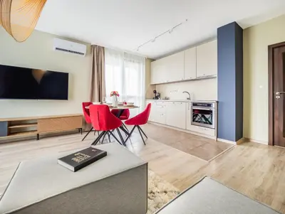 a kitchen and living room with a table and red chairs at The Boulevard Luxury Apartment 2 in Sofia