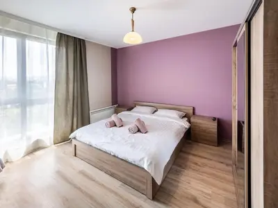 a bedroom with a bed with two pink towels on it at The Boulevard Luxury Apartment 2 in Sofia