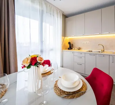 a kitchen with a white table with a vase of flowers at The Boulevard Luxury Apartment 2 in Sofia