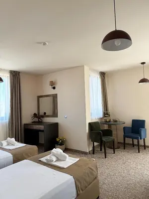 a hotel room with two beds and a desk at City Plaza in Botevgrad