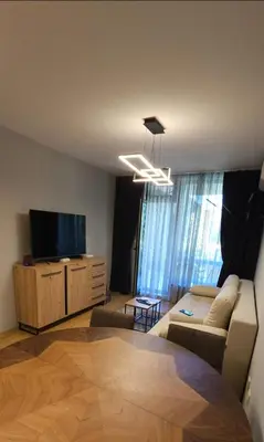 a living room with a couch and a flat screen tv at Aspen Suites Luxury apartment A005 in Razlog