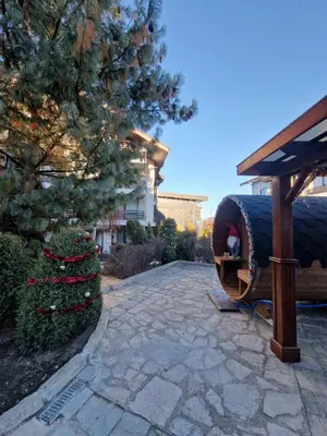 a stone walkway with a large barrel in a yard at Aspen Suites Luxury apartment A005 in Razlog
