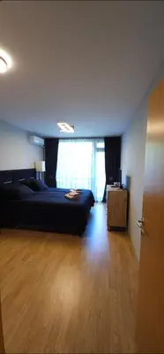 a bedroom with a black bed and a wooden floor at Aspen Suites Luxury apartment A005 in Razlog