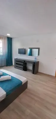 a large room with two beds and a television at Къща Росена - стаи за гости in Devin