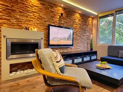 a living room with a fireplace and a tv at Mladost Sofia, close to Metro Station and Center in Sofia