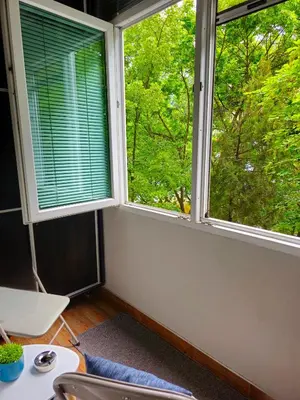 a room with two windows and a desk and a table at Mladost Sofia, close to Metro Station and Center in Sofia