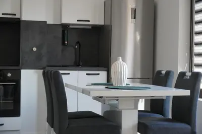 a kitchen with a white table and chairs at Panorama view free parking in Sofia
