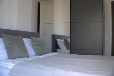 a bed with white sheets and pillows in a bedroom at Panorama view free parking in Sofia