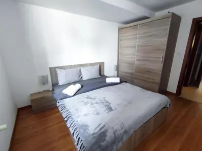 a bedroom with a large bed and a wooden floor at Belvedere Holiday Club K106 in Bansko