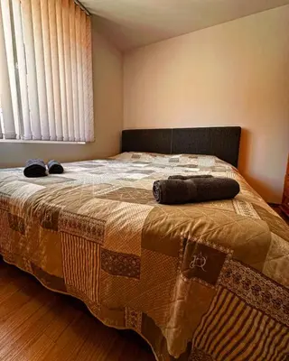 a bedroom with a large bed with two shoes on it at Къща за гости Димитрови guest house Dimitrovi in Devin