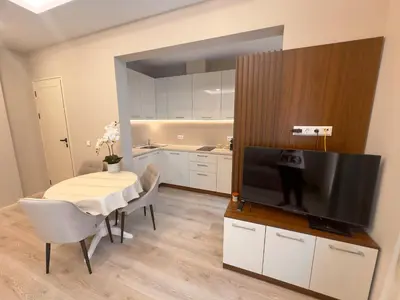 a living room with a table and a flat screen tv at Luxury Apartments 1 in Sofia