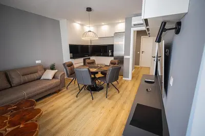 a living room with a couch and a table at Gran Capital - Vodolei Garden, FREE Parking in Sofia