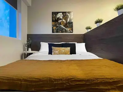 a bedroom with a large bed with a wooden headboard at High Rise Studio by Cosher in Sofia