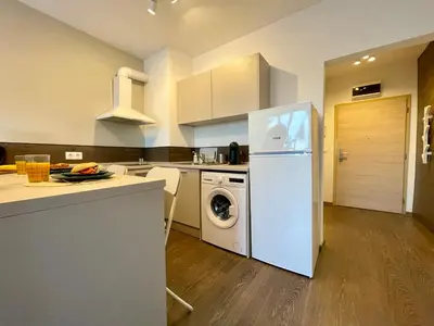 a kitchen with a white refrigerator and a dishwasher at High Rise Studio by Cosher in Sofia