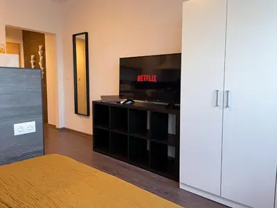 a living room with a flat screen tv and a entertainment center at High Rise Studio by Cosher in Sofia