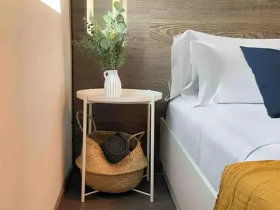 a table with a vase on it next to a bed at High Rise Studio by Cosher in Sofia