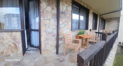 a patio with a table and chairs and windows at Guest Suite in Bansko