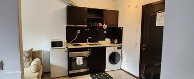 a small kitchen with a washing machine and a washer at Guest Suite in Bansko