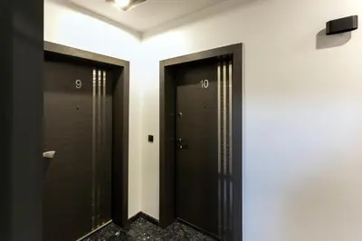 two black doors in a room with white walls at Relax Apartment in Sofia