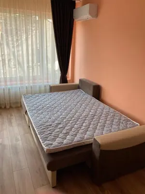 a bed in a room next to a window at Relax Apartment in Sofia