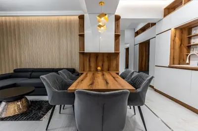 a living room with a wooden table and chairs at Vitoshka Luxury 2-BR Retreat in Sofia
