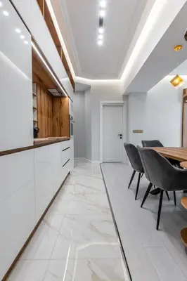 a kitchen with white cabinets and a table and chairs at Vitoshka Luxury 2-BR Retreat in Sofia