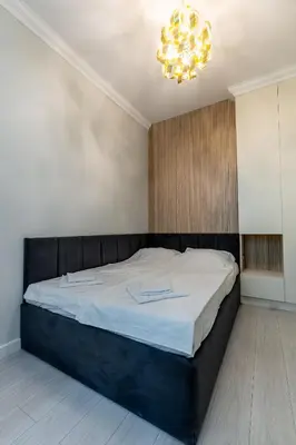 a bedroom with a large bed with a chandelier at Vitoshka Luxury 2-BR Retreat in Sofia
