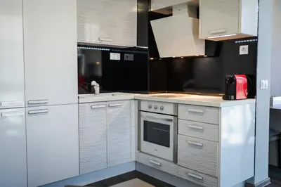 a kitchen with white cabinets and a red appliance at Dias in Sandanski