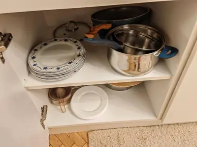 a cupboard with a pot and plates and bowls at Apartament 86 in Sofia