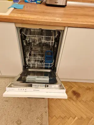 an open dishwasher sitting under a kitchen counter at Apartament 86 in Sofia