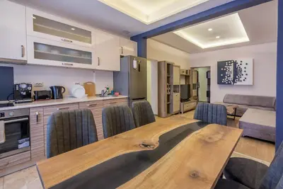 a kitchen and living room with a wooden table and chairs at 3BDR, Top Center Retreat, Sofia Heart, FREE Parking in Sofia