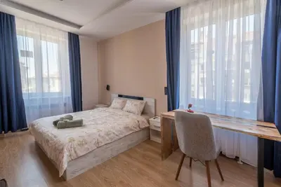 a bedroom with a bed and a desk and windows at 3BDR, Top Center Retreat, Sofia Heart, FREE Parking in Sofia