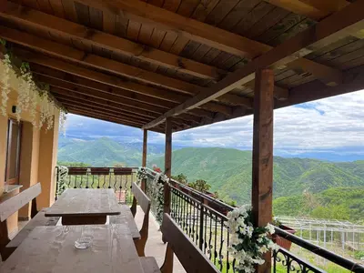 a wooden table on a balcony with a view of mountains at Villa Garden in Kremen